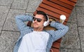 Man with headphones lying on a bench Royalty Free Stock Photo