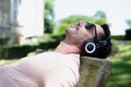 man with headphones lying on park bench outdoors Royalty Free Stock Photo