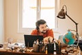 Man with headphones and microphone having conference call online sitting at home office with two laptops. Working from home Royalty Free Stock Photo