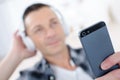 Man in headphones with mobile phone relaxing home Royalty Free Stock Photo