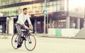 Man with headphones riding bicycle on city street Royalty Free Stock Photo