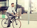 Man with headphones riding bicycle on city street Royalty Free Stock Photo