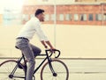 Man with headphones riding bicycle on city street Royalty Free Stock Photo