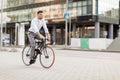 Man with headphones riding bicycle on city street Royalty Free Stock Photo