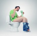 Man in headphones sitting on the toilet. Yes!