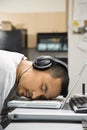 Man with headphones sleeping on laptop. Royalty Free Stock Photo