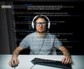 Man in headset hacking computer or programming