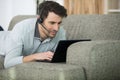 man with headset on sofa using laptop computer Royalty Free Stock Photo