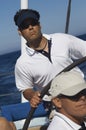 Man At The Helm Of A Sailboat In The Ocean