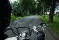 A man in a helmet on a classic black motorcycle rides on an asphalt road Royalty Free Stock Photo