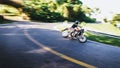 Man in helmet on classic motorcycle fits into turn on highway among the greenery