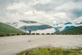 Man in helmet photographer taking photos back view of mountains landscape in rainy weather in Norway. Travel Lifestyle Royalty Free Stock Photo