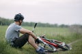 Man in helmet rest at the roadside with bicycle Royalty Free Stock Photo