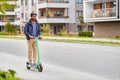 man in helmet riding electric scooter on street
