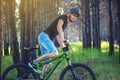 Man in a helmet riding on a green mountain bike in the woods. Cyclist in motion. Concept of active and healthy lifestyle Royalty Free Stock Photo