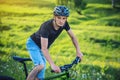 Man in a helmet riding on a mountain bike in the woods among the trees. Concept of active and healthy lifestyle Royalty Free Stock Photo