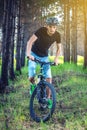 Man in a helmet riding on a mountain bike in the woods among the trees. Cyclist in motion. Active and healthy lifestyle