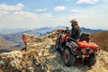 Man in helmet sitting on ATV quad bike in mountains