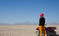 Man in helmet stands near an ATV in desert Royalty Free Stock Photo