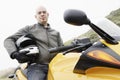 Man with helmet underarm sitting on a motorbike