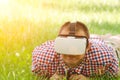 Man in a helmet of virtual reality lies on a green grass Royalty Free Stock Photo