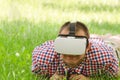 Man in a helmet of virtual reality lies on a green grass Royalty Free Stock Photo