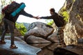 Man helping his girlfriend overstep water in canyon. Royalty Free Stock Photo