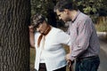 Man helping weak elderly woman with breathlessness attack during walk Royalty Free Stock Photo