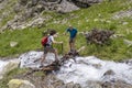 Man helping a woman to cross a mountain river