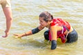 A man helps a woman athlete get out of a dirty hole in a hero race on a summer sunny day