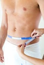 Man with a helthy body measuring his stomach. Diet concept. Royalty Free Stock Photo