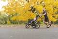 Man with her daughter in jogging stroller outside in autumn nature Royalty Free Stock Photo