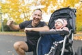 Man with her daughter standing in jogging stroller outside in autumn nature Royalty Free Stock Photo