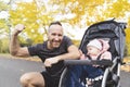 Man with her daughter standing in jogging stroller outside in autumn nature Royalty Free Stock Photo