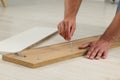 Man with hex key assembling furniture on floor indoors, closeup Royalty Free Stock Photo