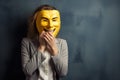 A man hides his face behind a yellow smiling mask Royalty Free Stock Photo