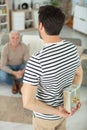 man hides present for senior man behind back Royalty Free Stock Photo