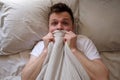 Man hiding in bed under the blanket at home Royalty Free Stock Photo