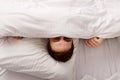 Man hiding in bed under sheets. Royalty Free Stock Photo