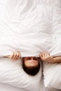 Man hiding in bed under sheets. Royalty Free Stock Photo