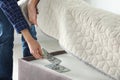 Man hiding dollar banknotes under mattress in bedroom. Money savings