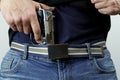 Man is hiding a handgun under the denim belt. Royalty Free Stock Photo