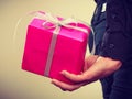 Man hiding pink gift box with ribbon behind back Royalty Free Stock Photo