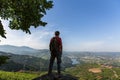 Man hiker with backpack standing on top of a mountain and enjoying the view of Douro Valley