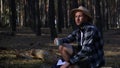 Man hiker drinks tea during a halt in the forest. Concept hike, tourism.