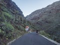 Man hiker figure at Guarimiar village road. At hiking trail through Barranco de Guarimiar Gorge. Green mountain canyon