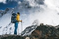 Man hiker going mountain track. Solo traveling with touristick backpack across mountains