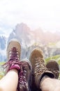 Man hiker lie on a ground. Peaks like a background. Sunny day.Trekking boots.Lens flare. Succesful backpacker enjoy a view.