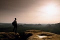 Man hiker at mountain peak. Marvelous daybreak in autumn misty landscape.