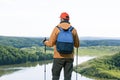 Man hiker observing the the green valley with lake and thinking.